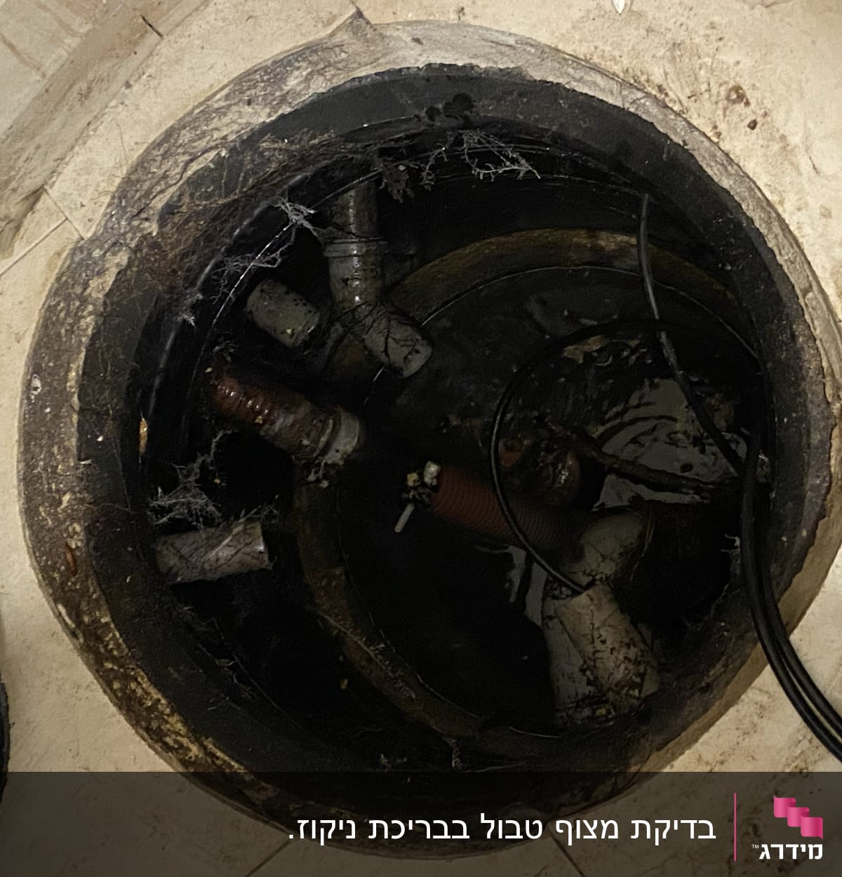 צינורות ביוב עם מים ולכלוך בתוך בור פתוח